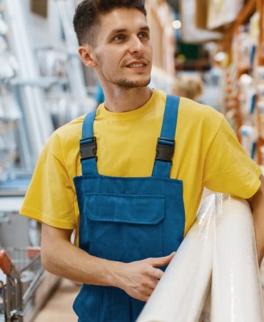 2-builder-with-roll-of-wallpapers-in-hardware-store-RAF55XH.jpg